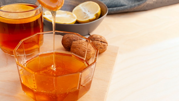 Free photo close-up honey pouring into glass