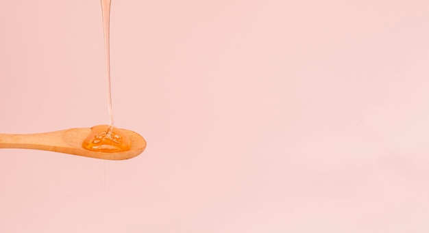 Free photo close-up honey pouring on a spoon