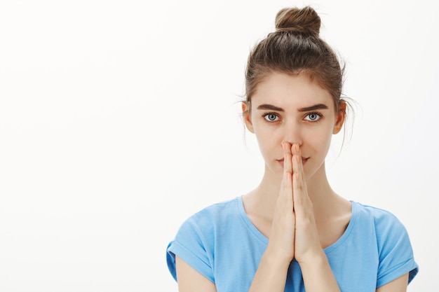 Close-up of hopeful young woman praying, pleading for gods help