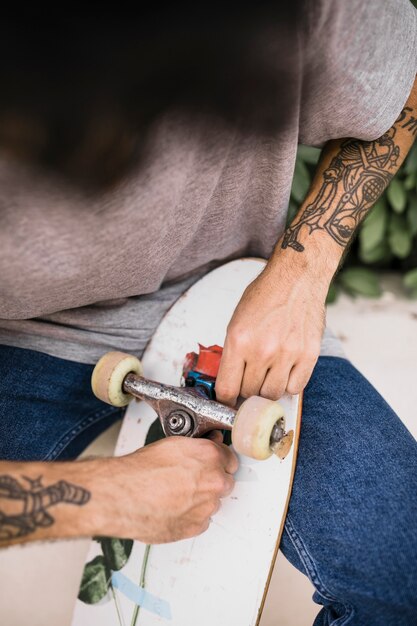 Close-up of human hands adjusting skateboards wheel