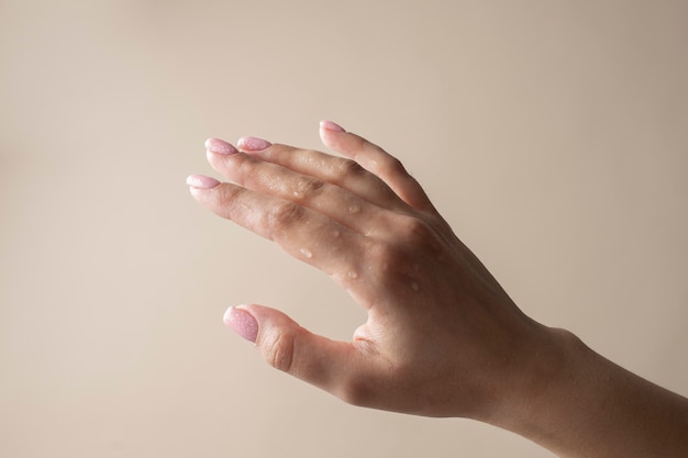 Close up hydrated hand with water drops