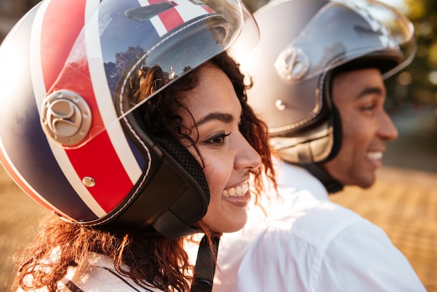 Free photo close up image of pleased african couple rides on modern motorbike on the street