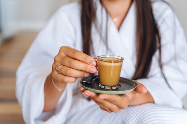 Close-up image of a woman holding a coffee mug.