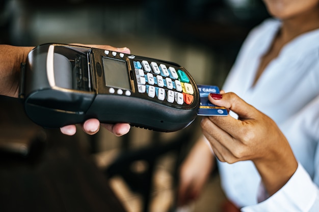 Free Photo close-up image of woman paying with credit card in cafe