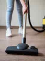 Free photo close-up individual using vacuum cleaner