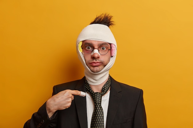 Close up on injured man with dark bruise under eyes and brain concussion, wears bandage