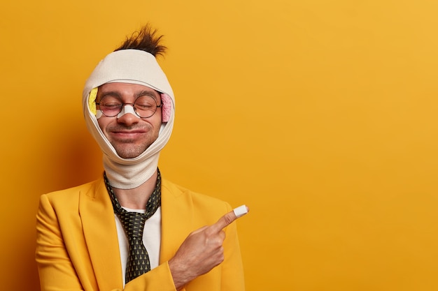 Free Photo close up on injured man with dark bruise under eyes and brain concussion, wears bandage