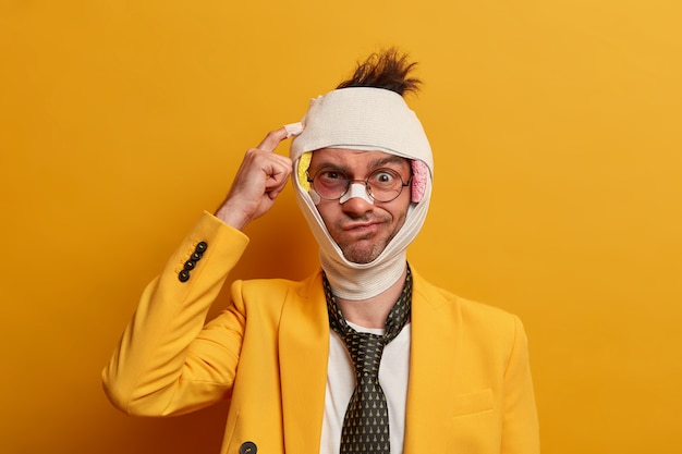 Free photo close up on injured man with dark bruise under eyes and brain concussion, wears bandage