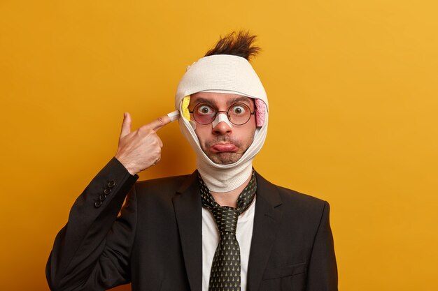 Close up on injured man with dark bruise under eyes and brain concussion, wears bandage