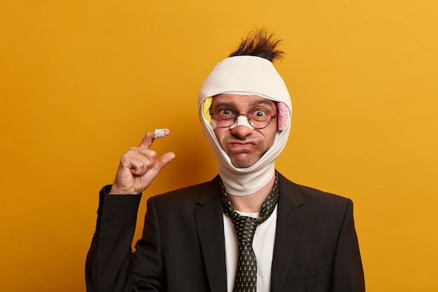 Close up on injured man with dark bruise under eyes and brain concussion, wears bandage