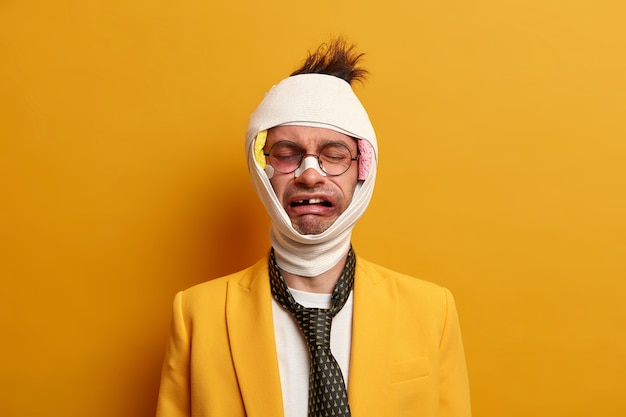 Free Photo close up on injured man with dark bruise under eyes and brain concussion, wears bandage