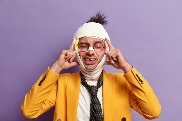 Free photo close up on injured man with dark bruise under eyes and brain concussion, wears bandage