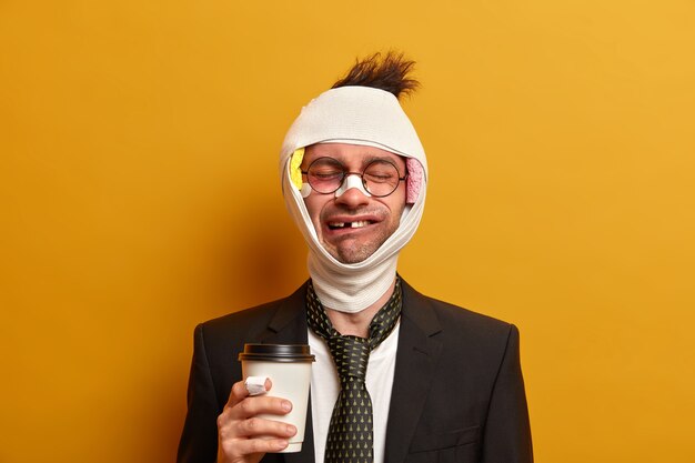 Close up on injured man with dark bruise under eyes and brain concussion, wears bandage