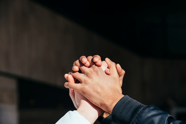 Close-up of interracial couple holding each other hands