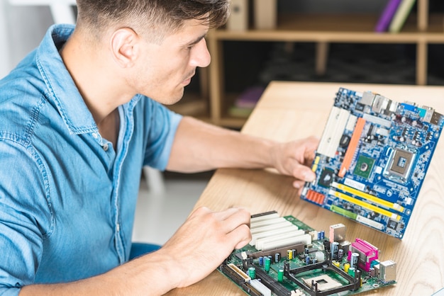 Free photo close-up of it man learning the motherboard circuit