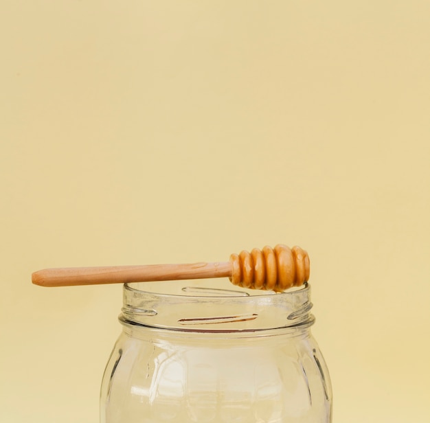 Free photo close-up jar with honey stick on top