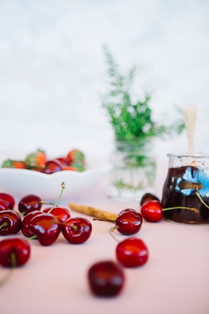 Close-up of juicy cherries with jam on desk