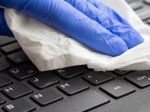 Close-up of keyboard being disinfected