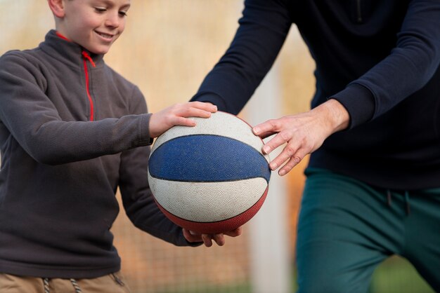 Close up kid and adult playing with ball