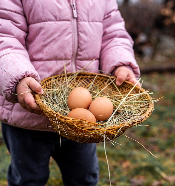 Free photo close-up kid holding basket with eggs