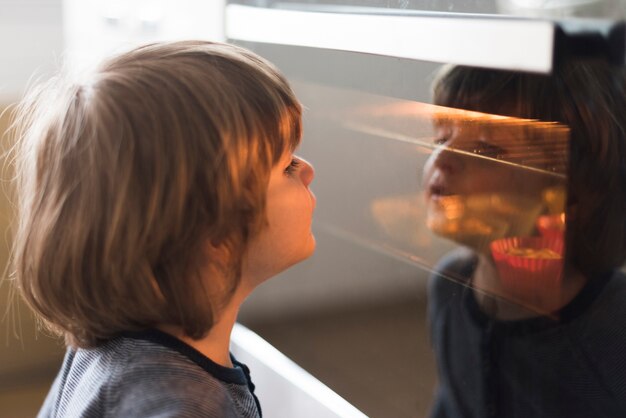 Close-up kid looking at oven