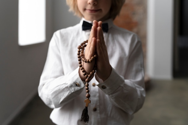 Free Photo close up kid praying with crucifix