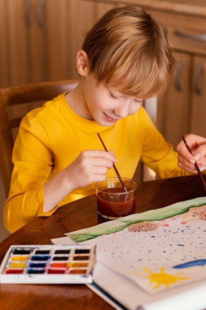 Close-up kid using watercolors