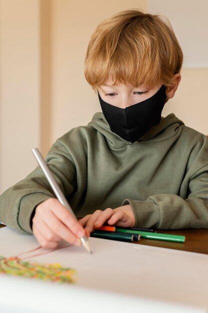 Close-up kid with mask drawing