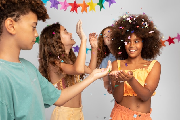 Close up kids celebrating with confetti