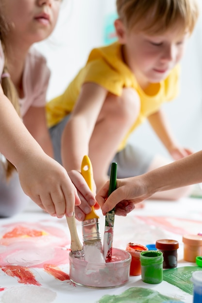 Close up kids holding brushes