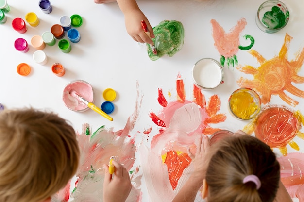 Close up kids painting with brushes together