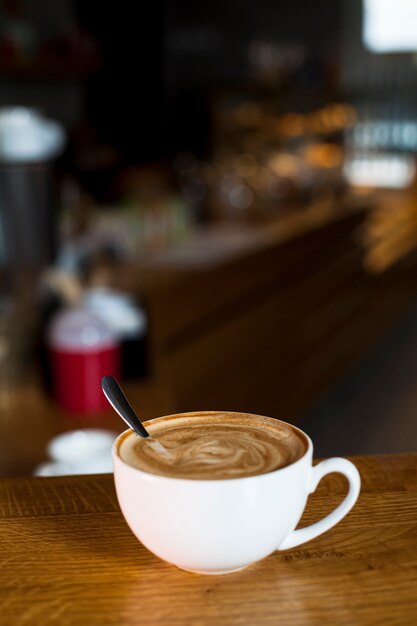 Close-up of latte coffee cup over table