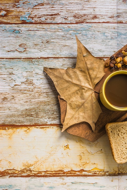 Close-up leaf and raisins near coffee and bread