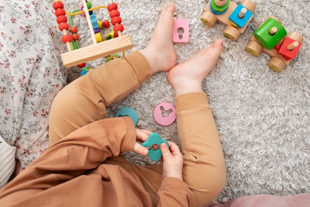 Close up little kid holding wooden toy