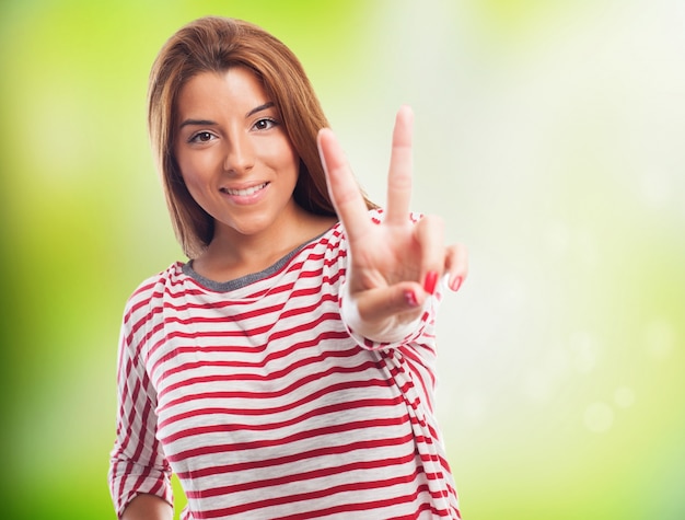 Close up of long haired woman, who smiling and showing peace sign