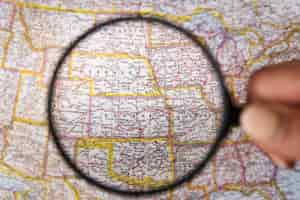 Free photo close up magnifying glass showing places on map