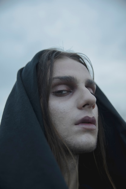 Free photo close-up make-up male witch with black hood