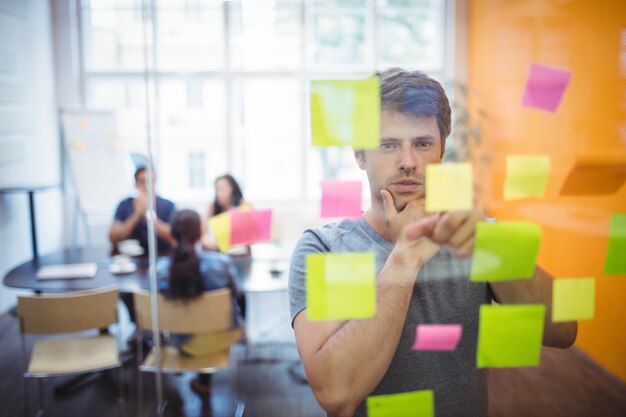 Close-up of male executive reading sticky notes