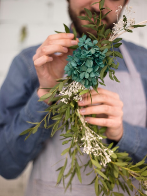 Free photo close-up of a male florist making wreath