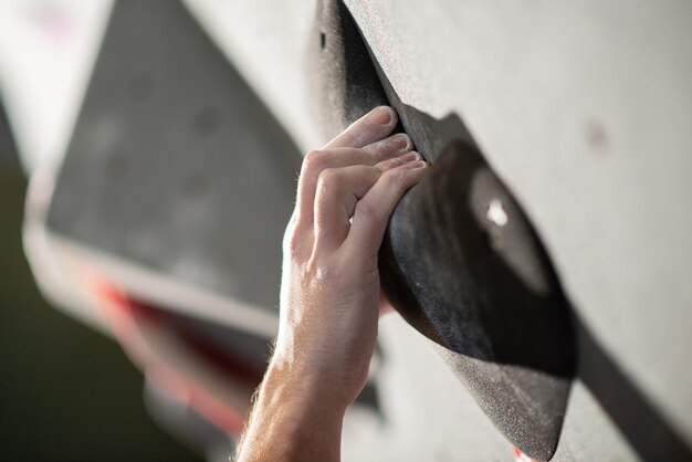 Close-up of male hand with talc powder on bouldering wall