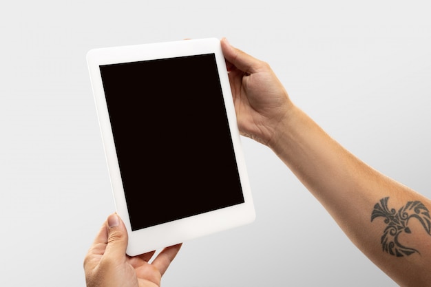 Close up male hands holding tablet with blank screen during online watching of popular sport matches and championships all around world.