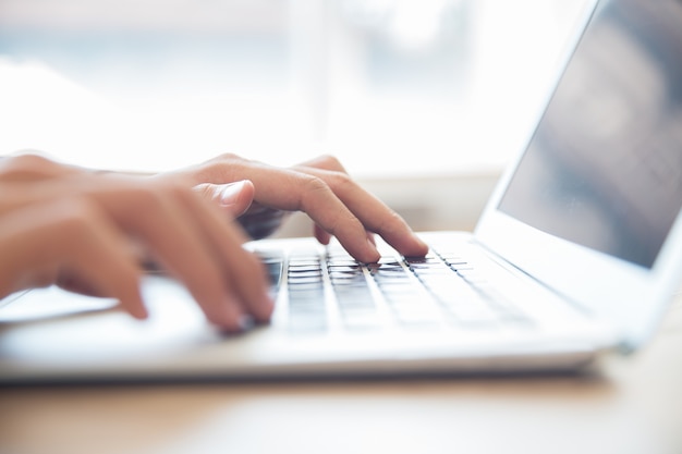 Close-up of male hands typing on laptop keyboard