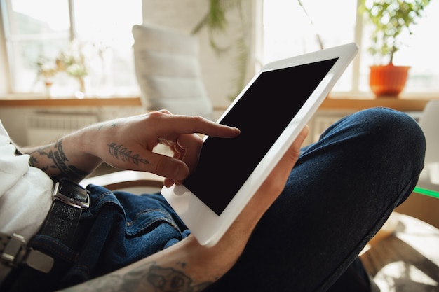 Close up of male hands using tablet with blank screen, copyspace. Surfing, online shopping, scrolling, betting, working. Education, freelance, art and business concept. Watching cinema, reading book.