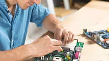 Free photo close-up of male technician assembling motherboard