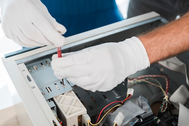 Free photo close-up of a male technician hand wearing gloves repairing computer