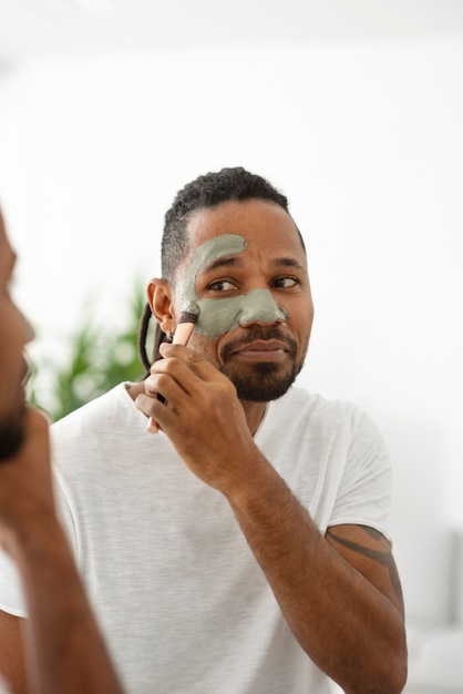 Free Photo close up man applying face treatment with brush