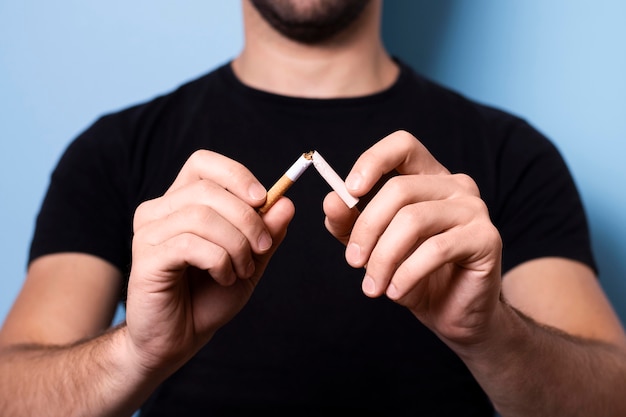 Close-up man breaking cigarette