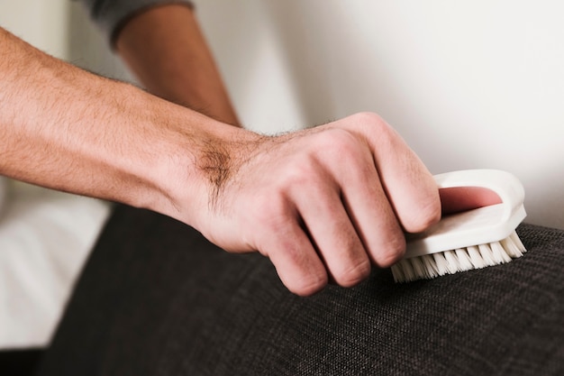 Free Photo close up man brushing couch