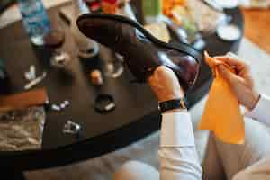 Free photo close up of man cleaning shoes while getting ready wedding ceremony