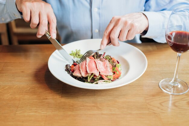 Close-up man cutting food at restaurant